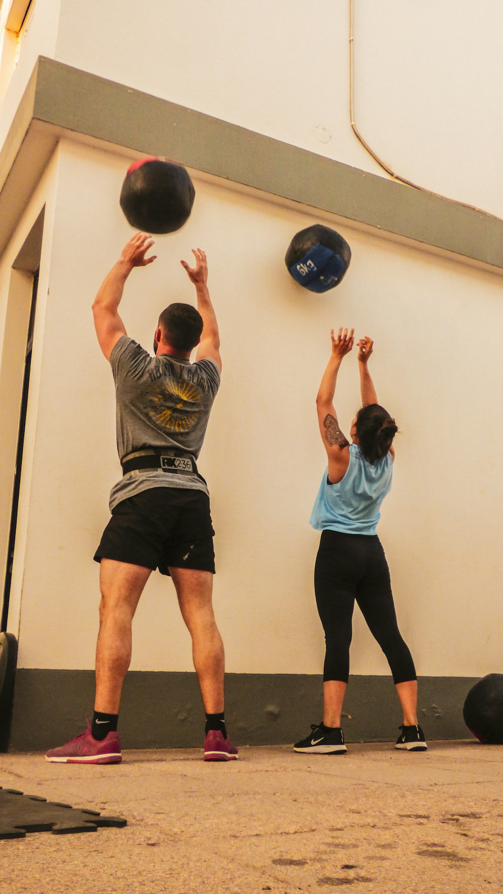 man in gray shirt and black shorts holding blue ball