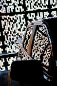 A shiny car is parked with an intricate pattern of small rectangular lights reflecting on its surface. The background features a decorative wall with geometric designs created by the same light pattern.