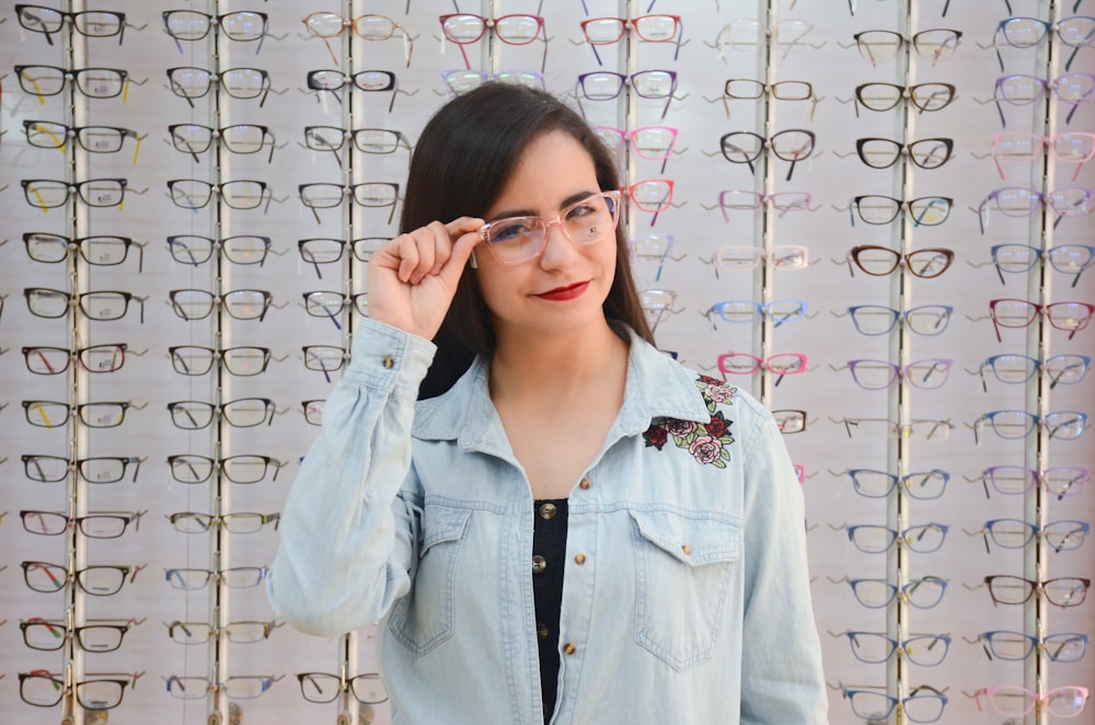 woman in blue denim jacket wearing eyeglasses