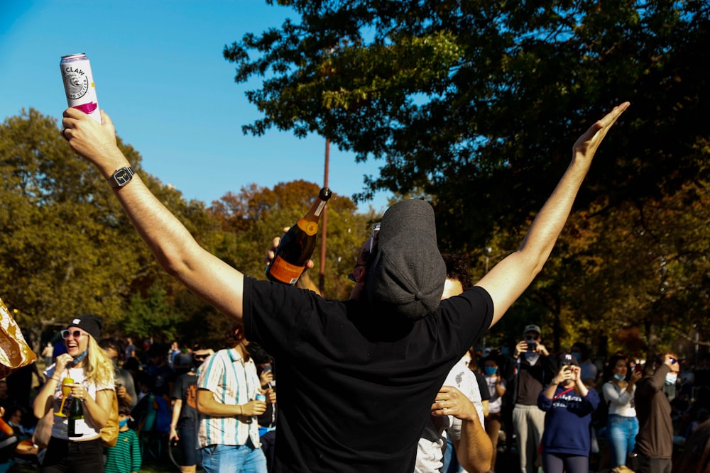 man in black t-shirt raising his hands