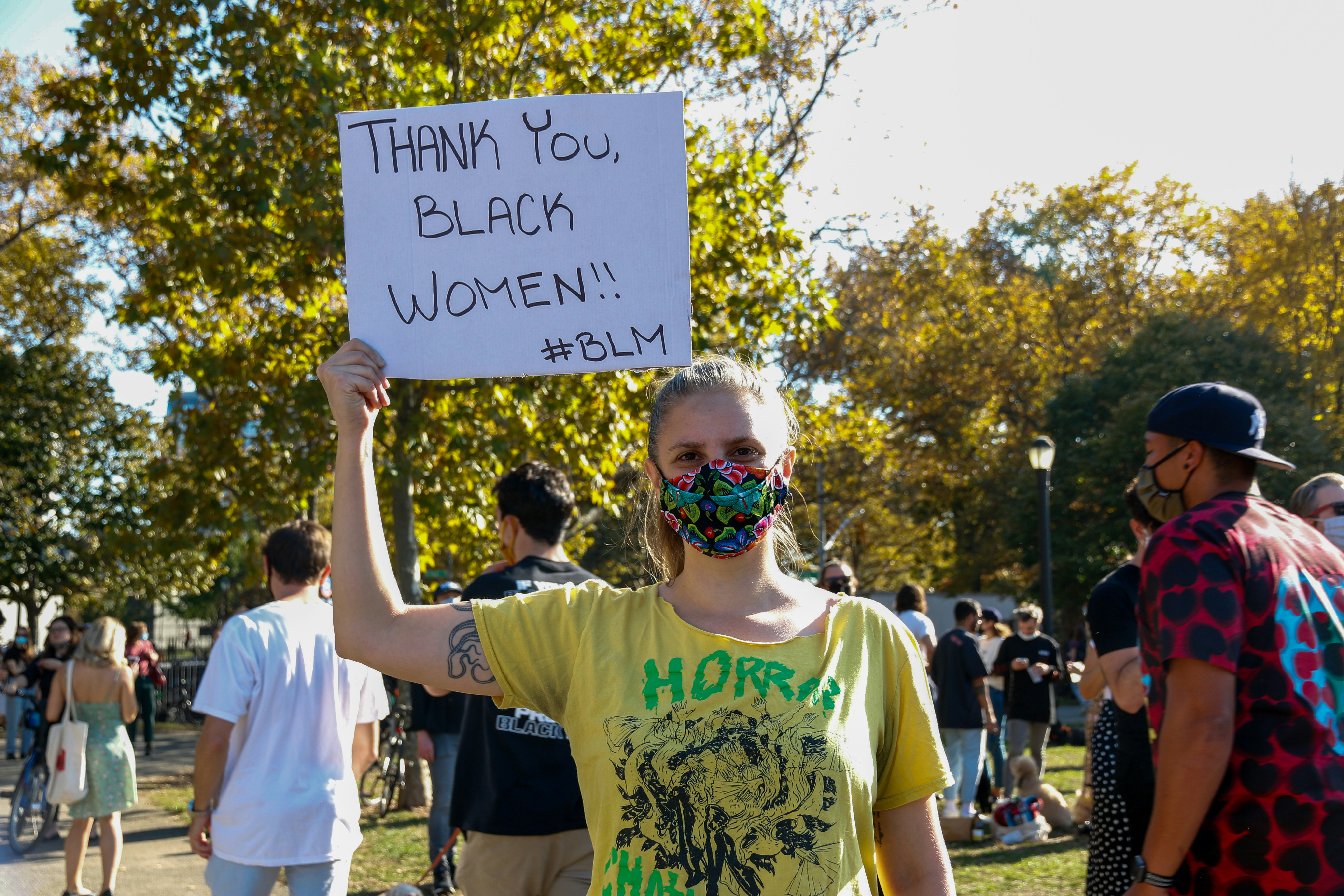 man in green and white crew neck t-shirt holding white printer paper during daytime