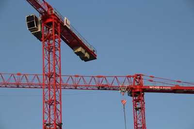 red and white crane under blue sky during daytime
