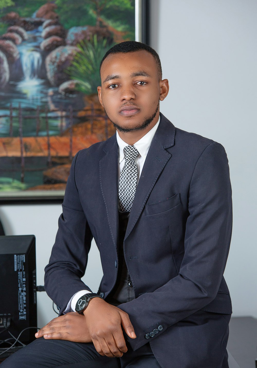 man in black suit jacket sitting on chair