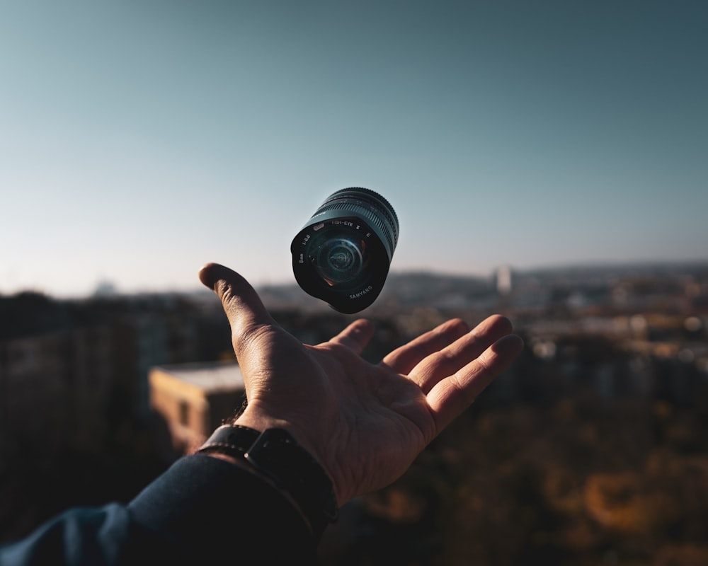 person holding black camera during daytime