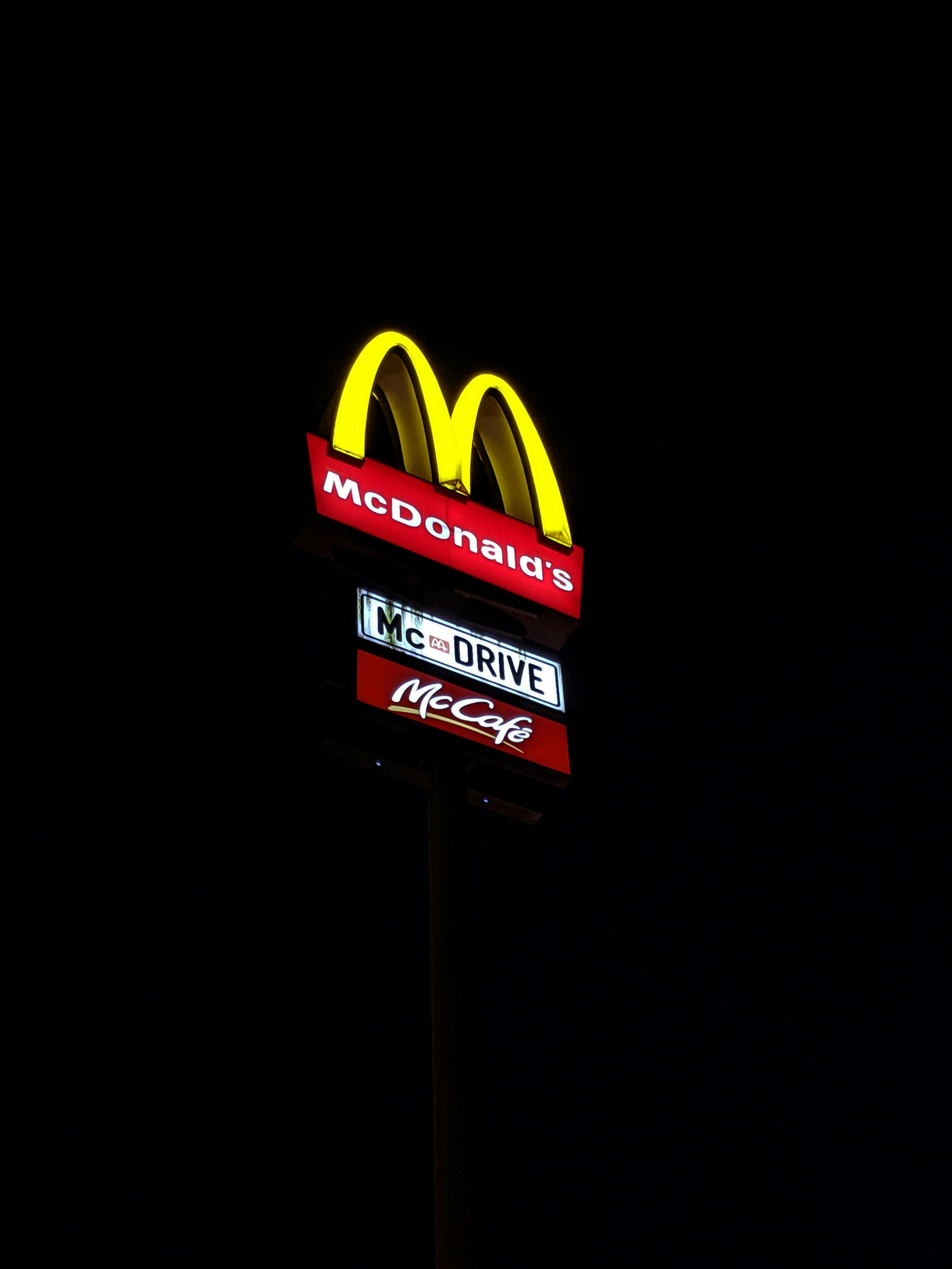 a mcdonald's sign lit up in the dark
