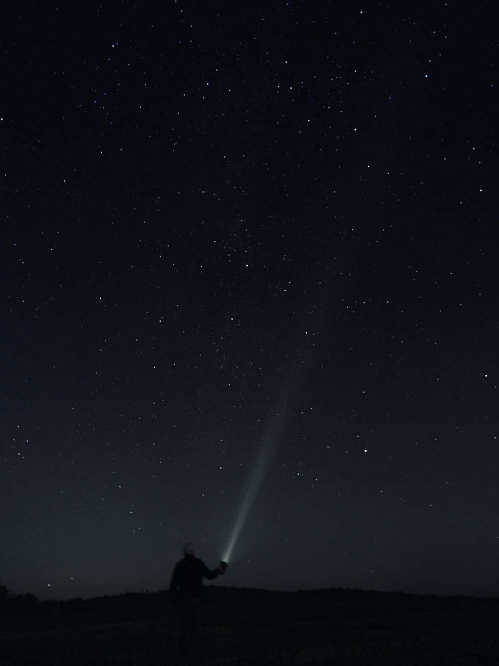 silhouette of man and woman standing under starry night