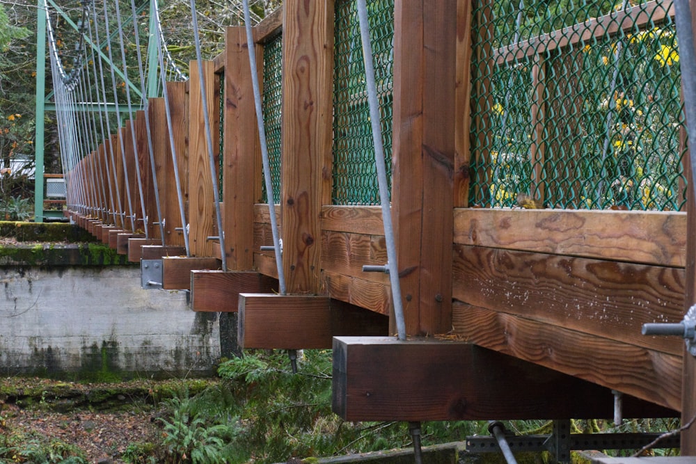 brown wooden bridge over green grass field