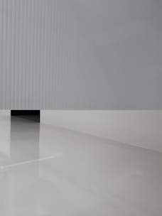 Close-up of a textured wall panel paired with cool-toned flooring in a minimalist space.