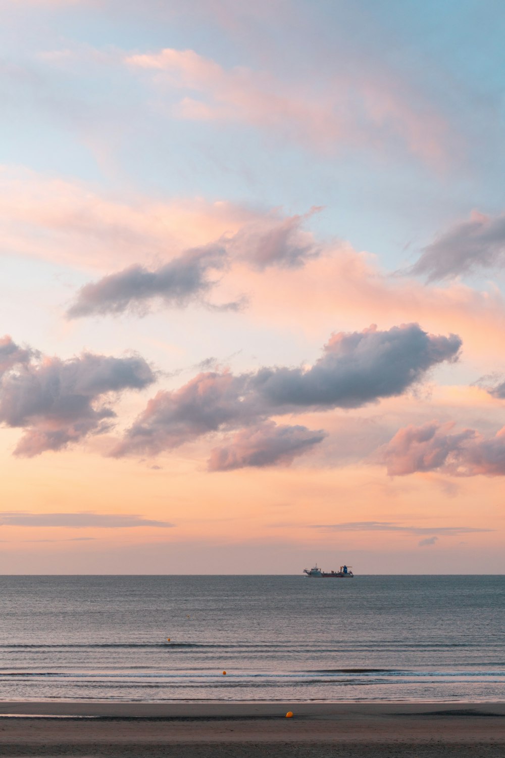 silhouette of boat on sea under cloudy sky during daytime