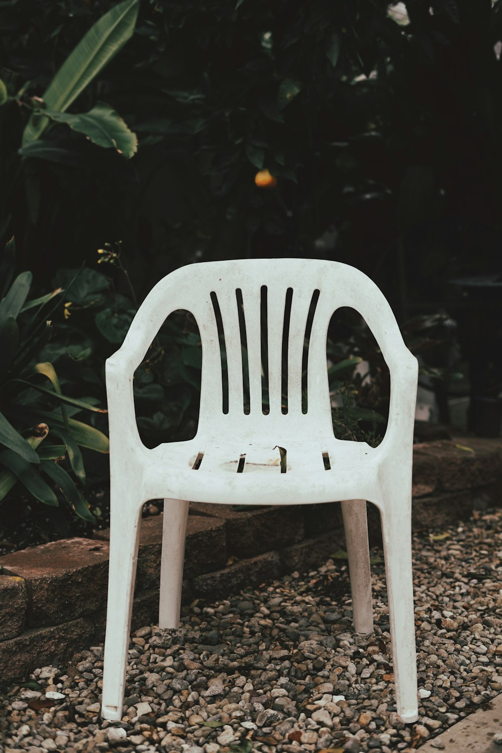 silla de plástico blanco sobre suelo marrón