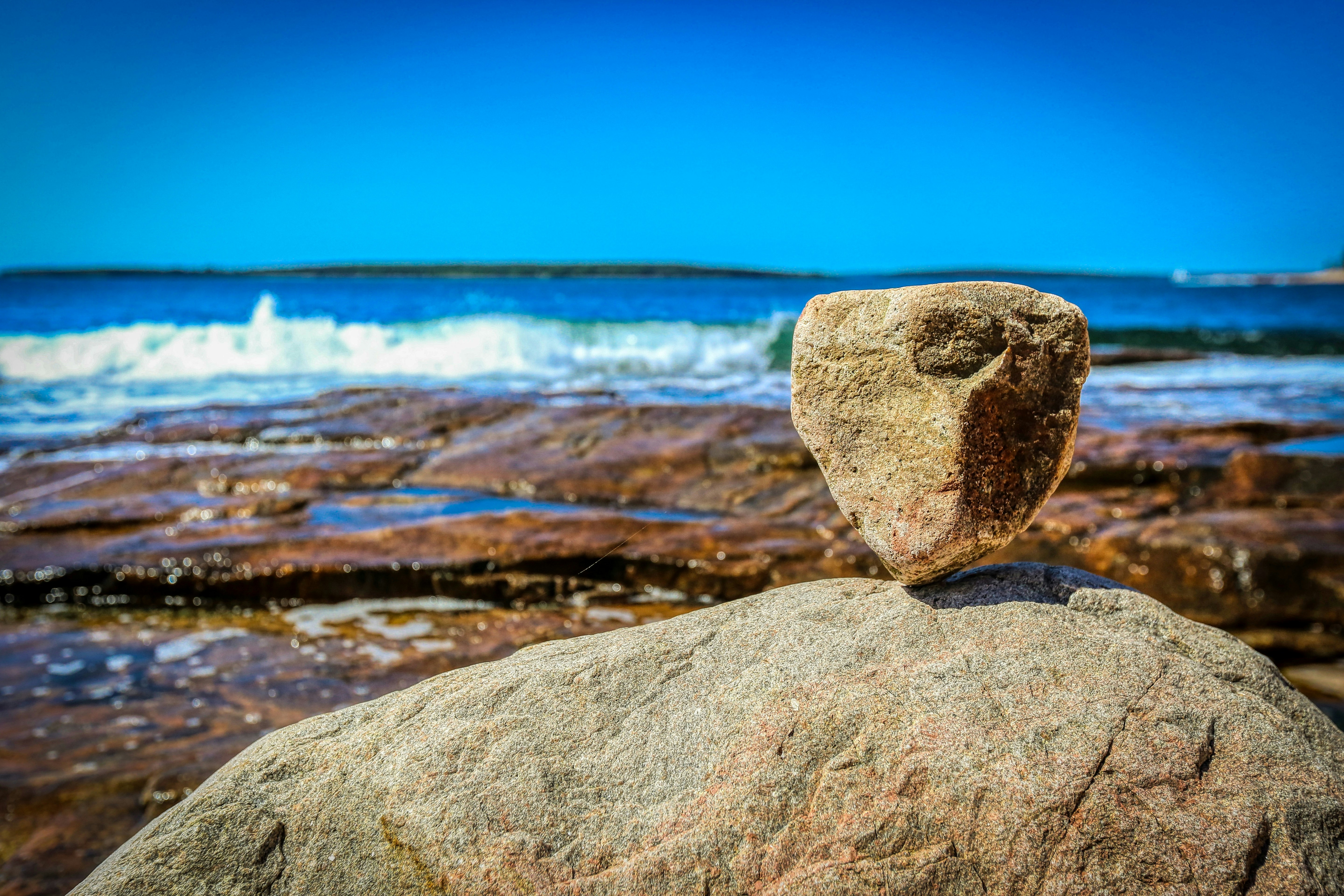 brown rock near body of water during daytime