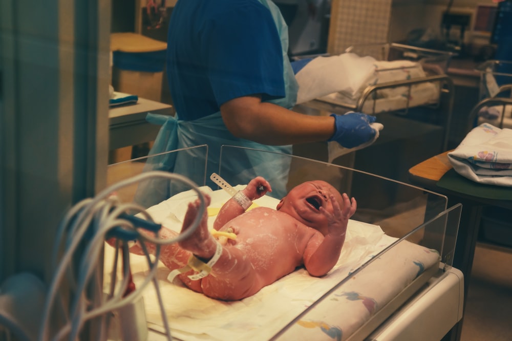 man in blue scrub suit holding baby