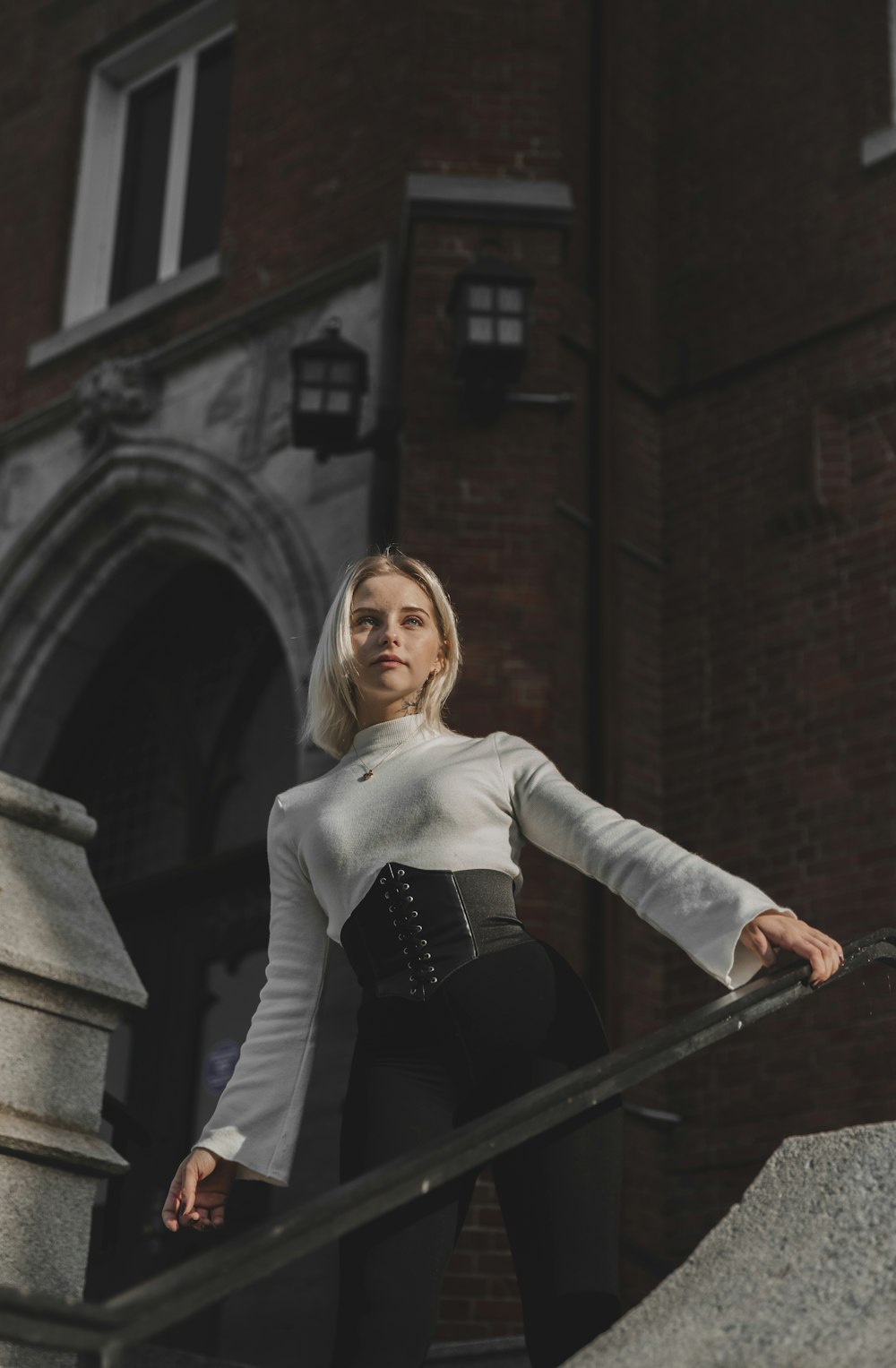 woman in white long sleeve shirt and black skirt standing on stairs