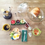 A warm breakfast spread with eggs, toast, fresh fruit, and a steaming cup of coffee by a window