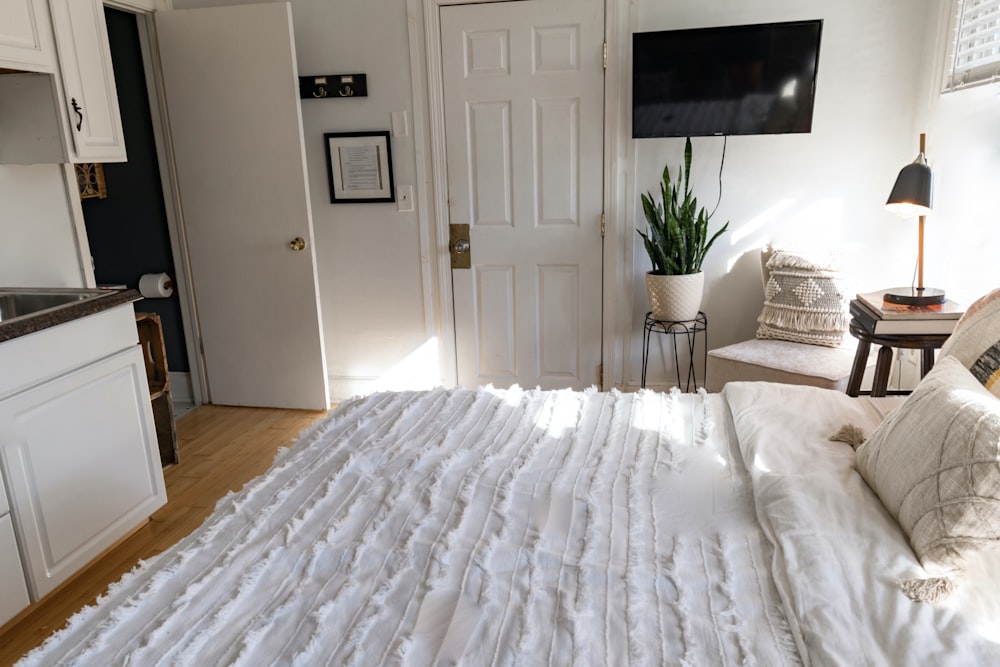 white bed cover near white wooden door