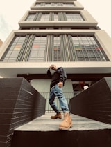 An image of a confident engineer standing in front of a modern building, representing success and achievement in their career.
