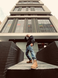 A confident woman standing in front of a modern office building, looking towards the horizon with determination.
