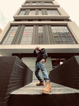 An image of a confident engineer standing in front of a modern building, representing success and achievement in their career.