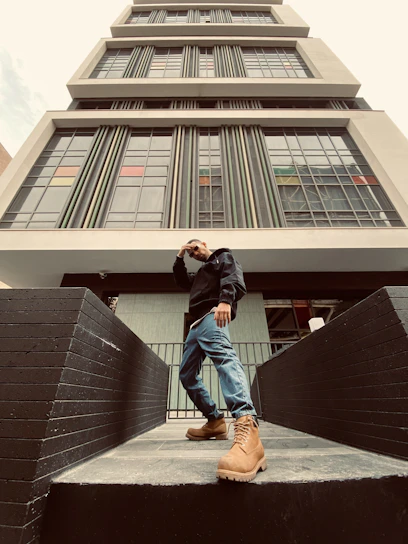 Portrait of the founder standing confidently in front of a clean commercial building.