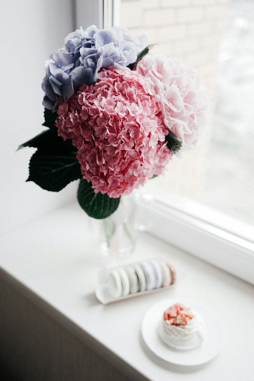 pink and white flower bouquet on white wooden table