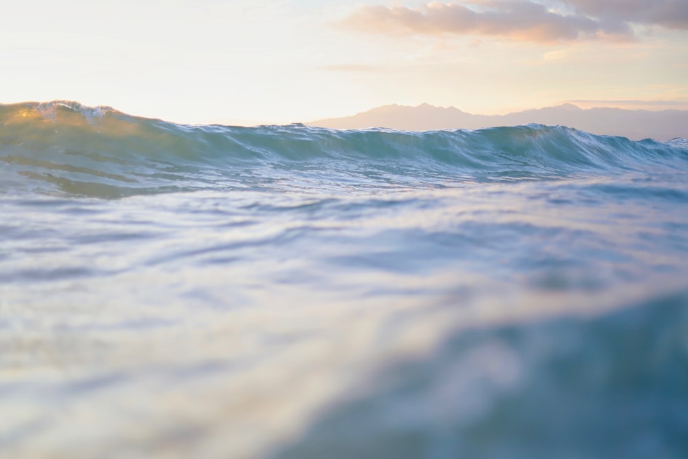 ondas do oceano sob o céu branco durante o dia