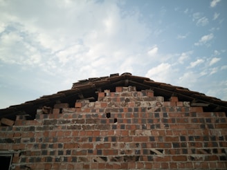 A partially built brick wall under a clear sky.