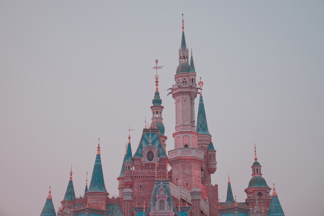 green and blue castle under white sky, Disneyland<p></figure>