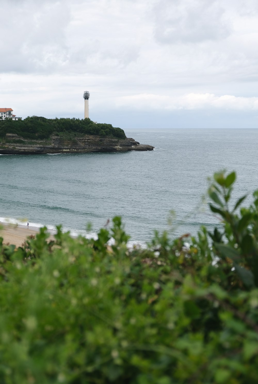 Faro blanco y negro cerca del cuerpo de agua durante el día