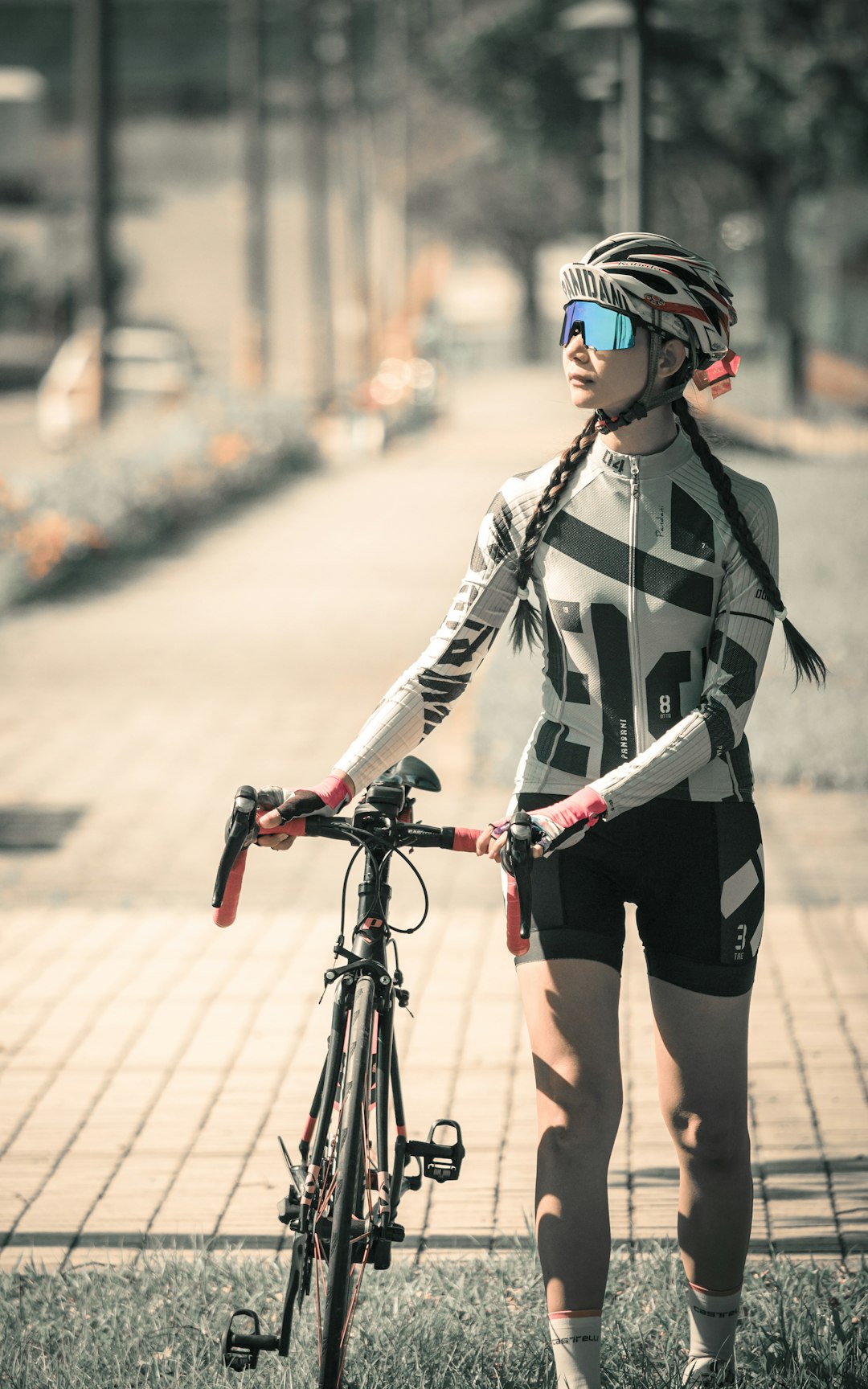 woman in black and white jacket and black shorts with black and red bicycle on road