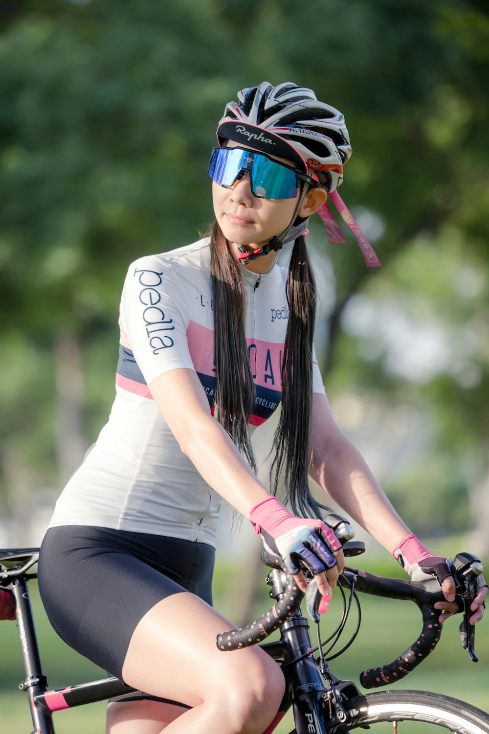 woman in white and red t-shirt riding bicycle during daytime