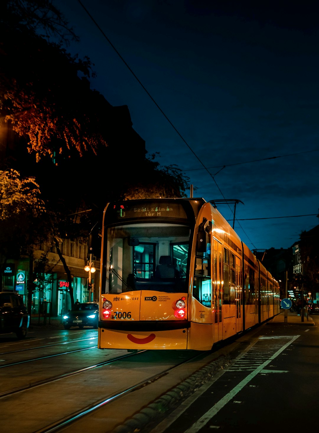 red tram on road during night time