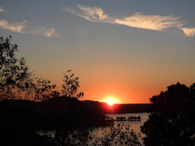 A vibrant sunset over Julington Creek with lush greenery and calm water reflecting the sky.