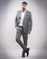 A man dressed in a tailored Lumina Apparel suit standing confidently against a minimalist backdrop.