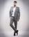 A stylish man wearing a minimalist, artsy outfit from épureluxe, standing against a soft, neutral background.