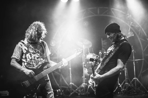 Musicians passionately playing guitars and drums during a lively practice session.