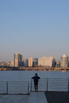 man in black jacket standing on dock during daytime