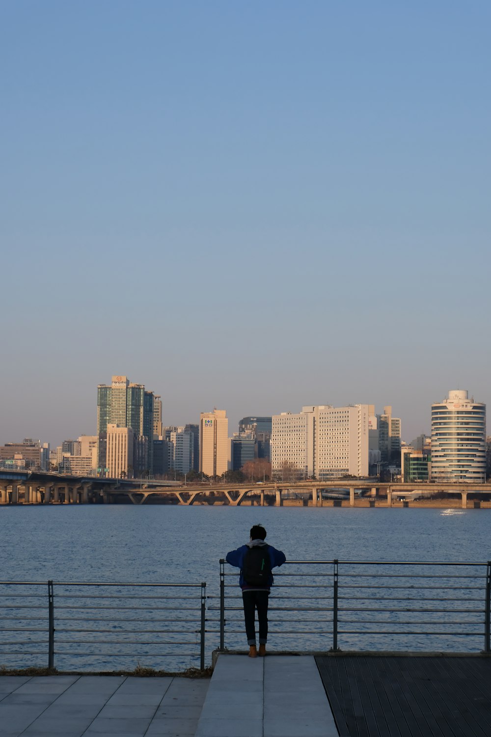 man in black jacket standing on dock during daytime