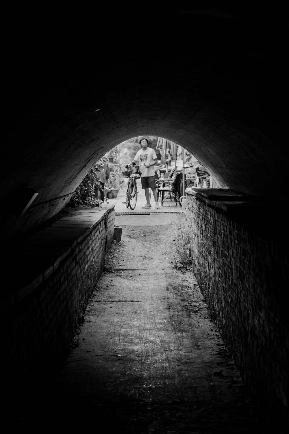 grayscale photo of people walking on tunnel