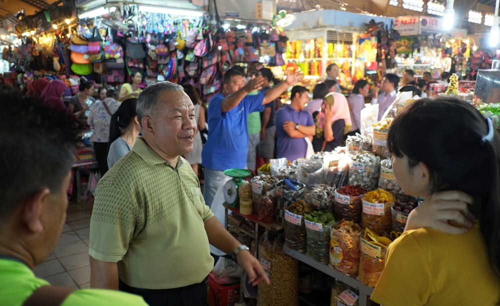 man in green and white checked button up shirt standing in front of people