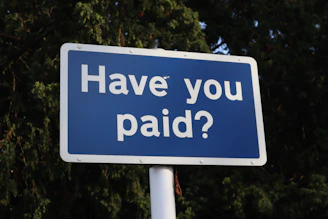 a blue sign that says have you paid?