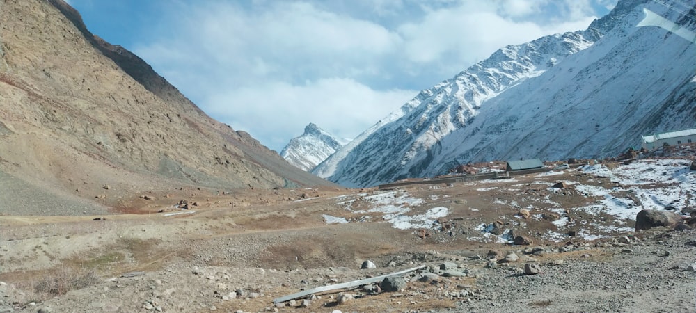 Montagnes blanches et brunes sous des nuages blancs pendant la journée