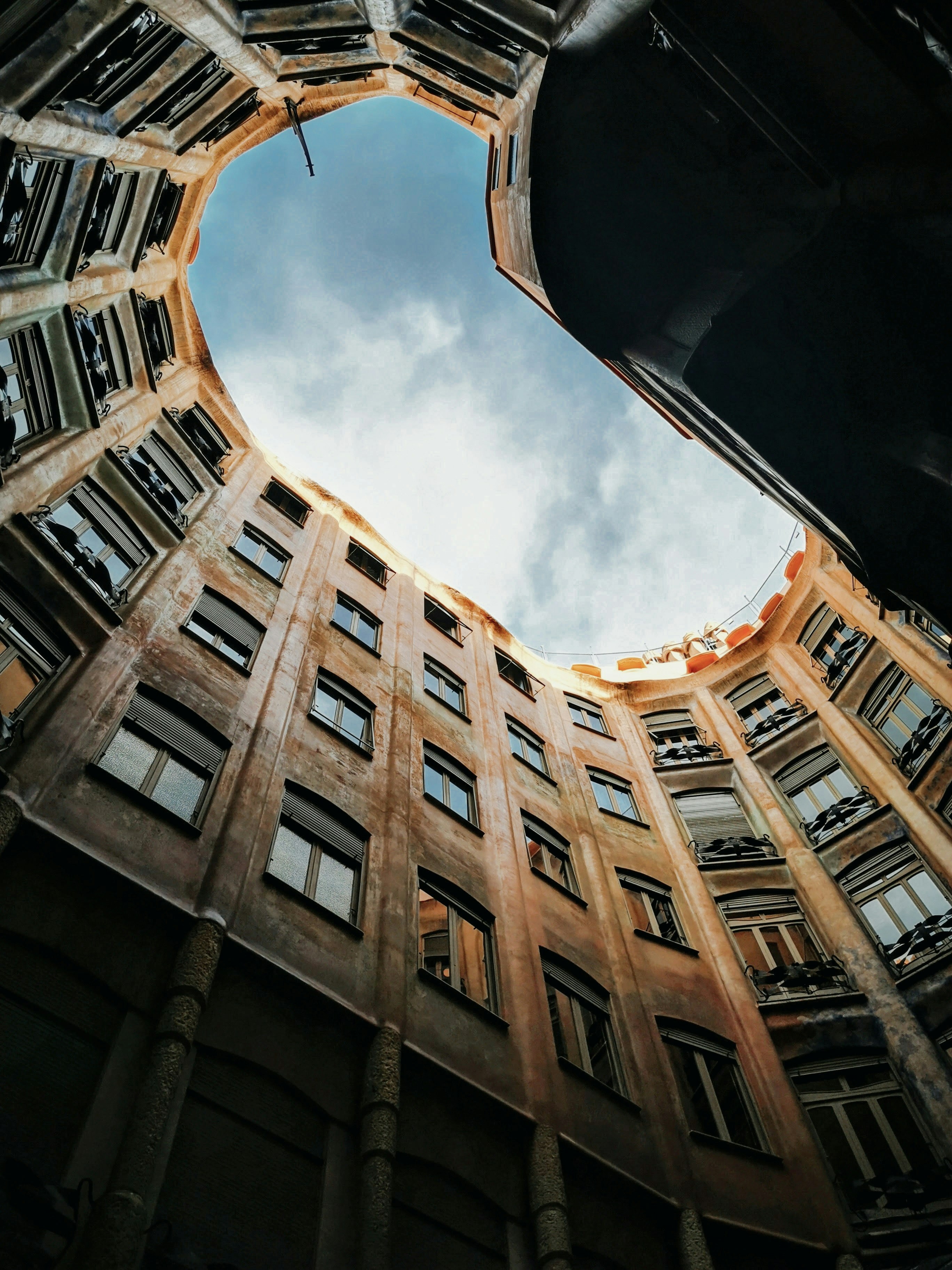 low angle photography of brown concrete building under blue sky during daytime