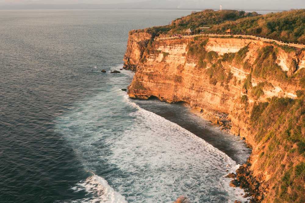 brown rock formation beside sea during daytime