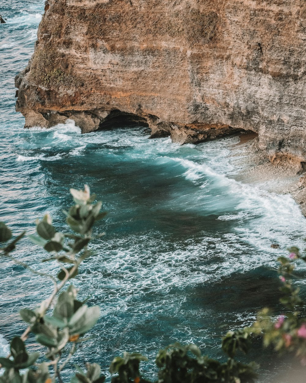 brown rock formation beside body of water during daytime