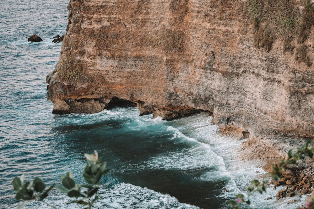 brown rock formation beside body of water during daytime