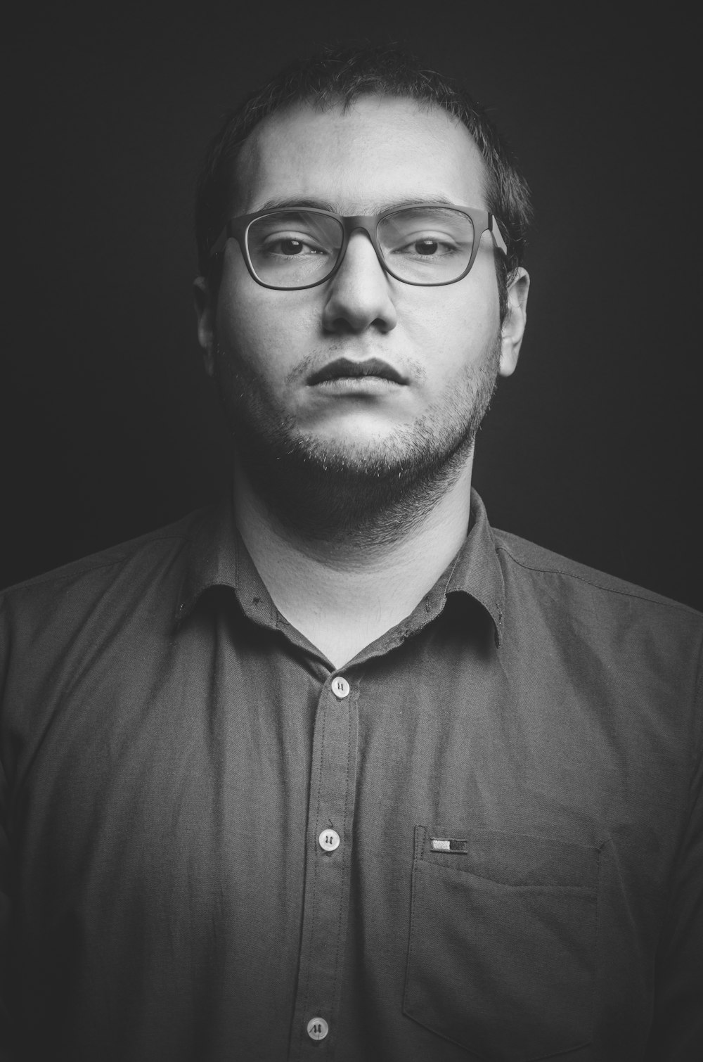 man in black button up shirt wearing black framed eyeglasses