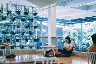 A group of young entrepreneurs brainstorming ideas surrounded by plants and eco-friendly materials.