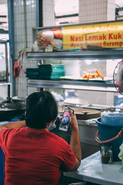 Malaysian small business owner checking her website on a smartphone