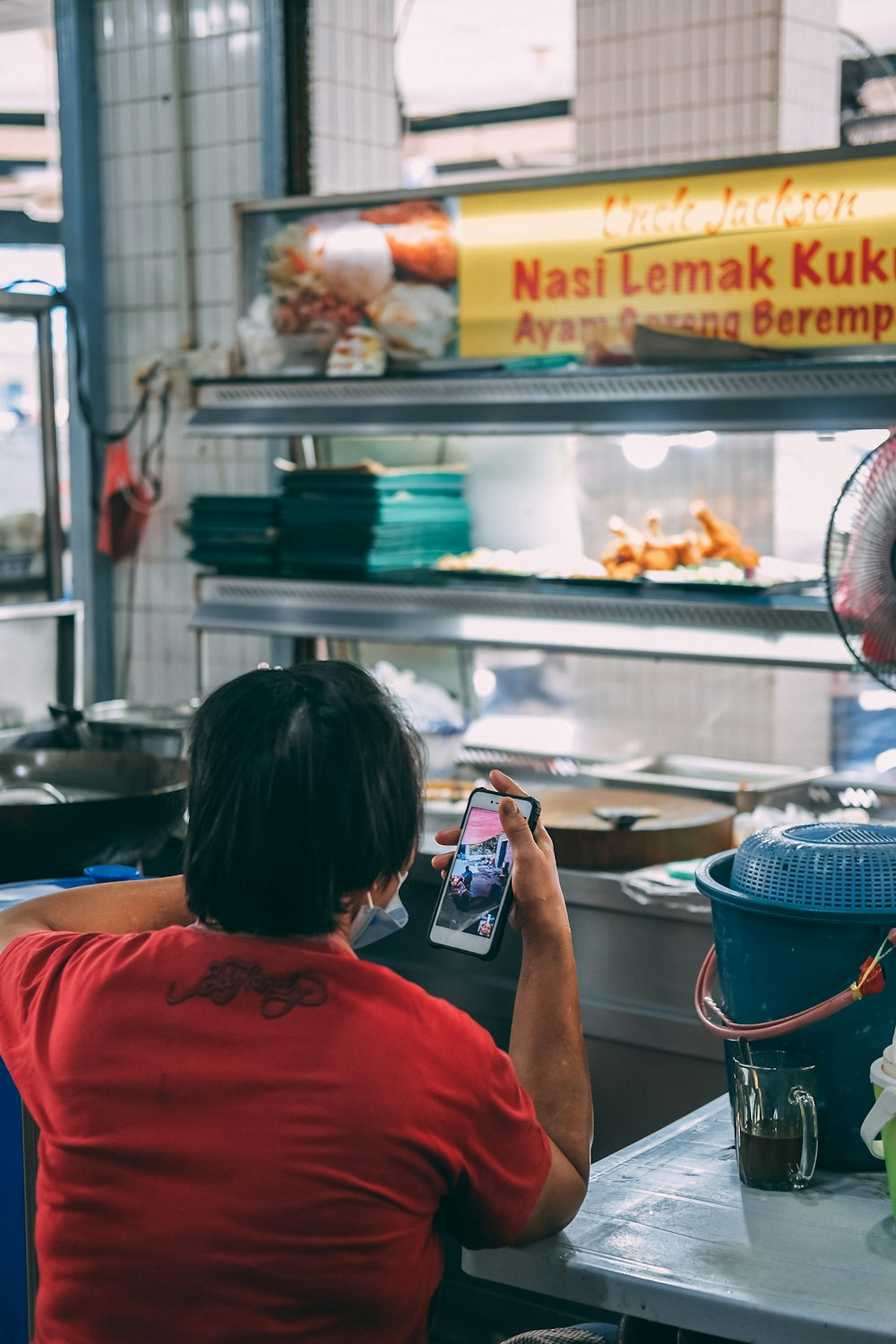 woman in red t-shirt holding smartphone