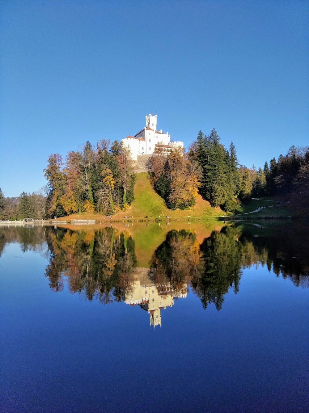 white and blue castle near lake during daytime